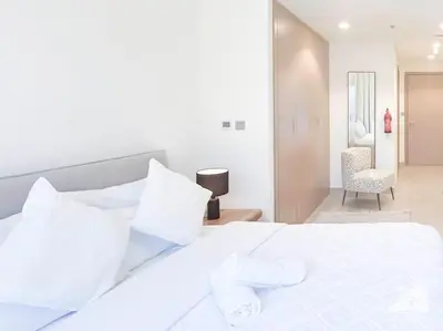 a white bed with white pillows in a bedroom at Elegant Stay in Meydan Balcony & Stunning Views in Dubai