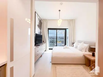 a white bedroom with a bed and a television at Elegant Stay in Meydan Balcony & Stunning Views in Dubai