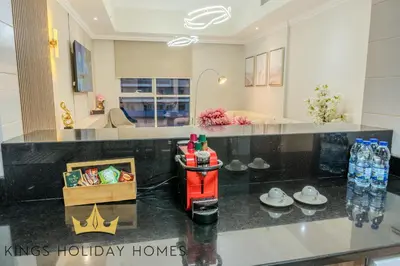 a kitchen with a black counter top and a living room at Luxury Apartments Dunya tower Burj Khalifa St kings in Dubai