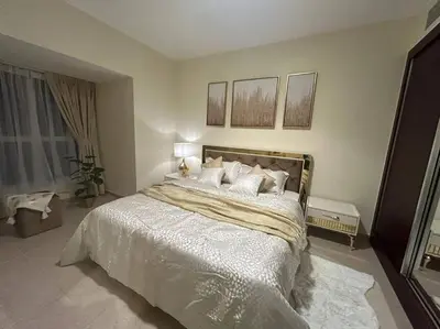 a bedroom with a large bed with white sheets and pillows at 1BHK in Dubai Marina near tram in Dubai