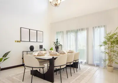 a dining room with a table and chairs at Cozy 4BR Maid Villa at Canal Cove Palm Jumeirah in Dubai