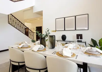 a dining room with a table and chairs at Cozy 4BR Maid Villa at Canal Cove Palm Jumeirah in Dubai