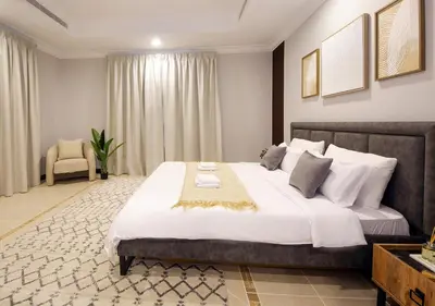 a bedroom with a large bed and a chair at Cozy 4BR Maid Villa at Canal Cove Palm Jumeirah in Dubai