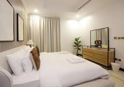 a bedroom with a large white bed and a dresser at Cozy 4BR Maid Villa at Canal Cove Palm Jumeirah in Dubai
