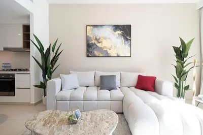 a living room with a white couch and a table at Dubai Mall Connected! AMAZING Burj Khalifa View! Excellent Pool & Gym Access! in Dubai