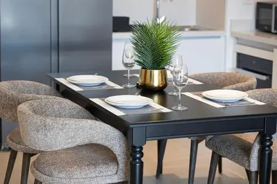a black dining table with chairs and a plant on it at Dubai Mall Connected! AMAZING Burj Khalifa View! Excellent Pool & Gym Access! in Dubai