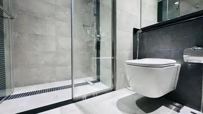 a bathroom with a toilet and a glass shower at Sunday Sheikh Zayed Road Concord Tower 2 BR by Belvilla in Dubai