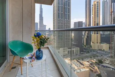 a balcony with a green chair and a vase of flowers at Frank Porter - Burj Views West in Dubai