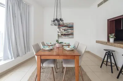 a dining room with a wooden table and chairs at Frank Porter - Burj Views West in Dubai