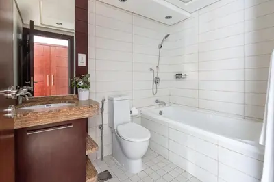 a bathroom with a toilet and a tub and a sink at Frank Porter - Burj Views West in Dubai