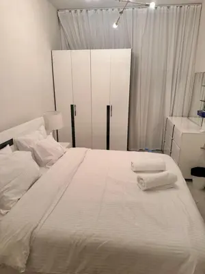 a bedroom with a large white bed with towels on it at Close to burj khalifa nice place in Dubai