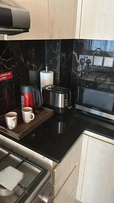 a kitchen counter with two cups on a cutting board at Close to burj khalifa nice place in Dubai
