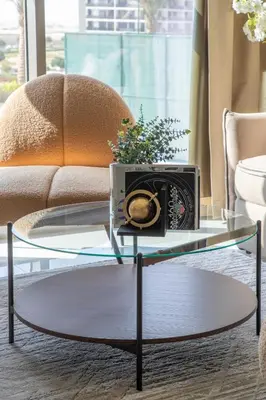 a glass coffee table in a living room with a microwave at Frank Porter - Wavez Residence in Dubai