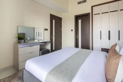 a bedroom with a large white bed and a bathroom at Frank Porter - Wavez Residence in Dubai
