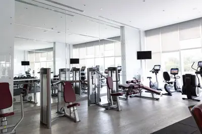 a gym with a bunch of treadmills and chairs in it at Frank Porter - Damac Heights in Dubai