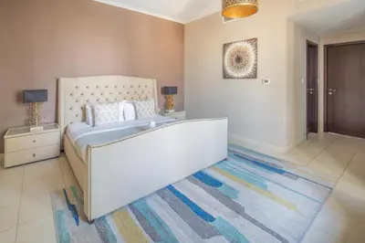 a bedroom with a large bed and a rug at Frank Porter - The Residences Tower 8 in Dubai