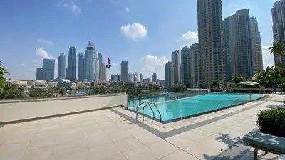 a swimming pool with a city skyline in the background at Near Burj Khalifa & Dubai Mall - 1BR in Grande Residence, Downtown - Allsopp & Allsopp in Dubai