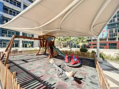 a play area with a playground with a large umbrella at Stunning 1 bedroom in JBR with Balcony - Dubai Marina Mall view in Dubai