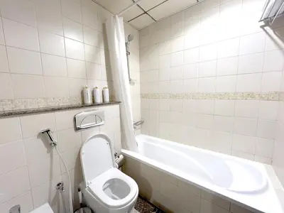 a white bathroom with a toilet and a bath tub at Stunning 1 bedroom in JBR with Balcony - Dubai Marina Mall view in Dubai