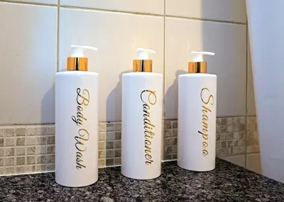 three white bottles sitting on a counter in a bathroom at Stunning 1 bedroom in JBR with Balcony - Dubai Marina Mall view in Dubai
