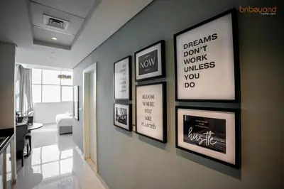 a hallway with framed pictures on a wall at Quirky Studio Apartment in Damac Ghalia in Dubai