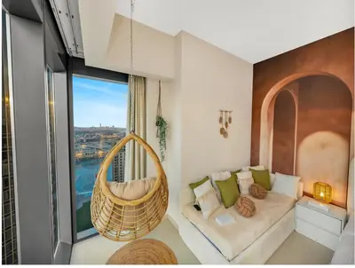 a living room with a couch and a large window at Wabi-Sabi Style Fountain-View 4 BR Apt in the Sky in Dubai