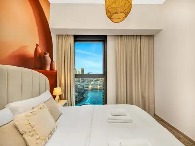 a bedroom with a white bed and a large window at Wabi-Sabi Style Fountain-View 4 BR Apt in the Sky in Dubai