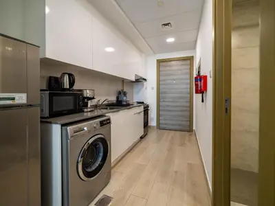 a kitchen with a washer and a dishwasher in it at Brand New Premium Studio In JVC in Dubai