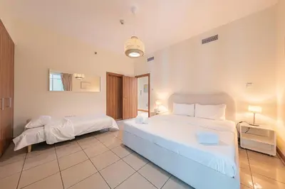 a large bedroom with two beds and a mirror at Spacious Upgraded & Elegant - 1BR in Dubai