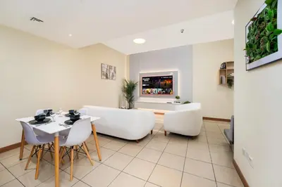 a dining room with white chairs and a table at Spacious Upgraded & Elegant - 1BR in Dubai