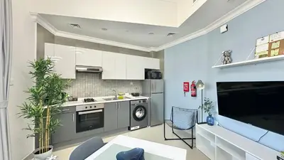 a kitchen with a stove and a dishwasher at Spacious Luxury Studio Near Mall of the Emirates with Pool Access in Dubai