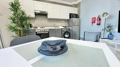 a kitchen with a table with a hat on it at Spacious Luxury Studio Near Mall of the Emirates with Pool Access in Dubai