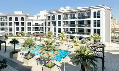 an overhead view of a building with a pool and palm trees at Spacious Luxury Studio Near Mall of the Emirates with Pool Access in Dubai