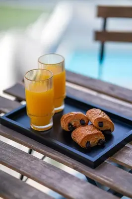 a tray with two glasses of orange juice and pastries at New Cosy 1BR with Pool & Gym in City Centre in Dubai