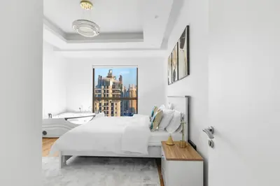a white bedroom with a large bed and a window at 2BR Marina View - Beach Access - Sleeps 8 in JBR in Dubai
