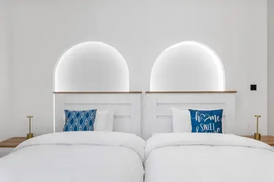 two white beds with blue pillows in a bedroom at 2BR Marina View - Beach Access - Sleeps 8 in JBR in Dubai