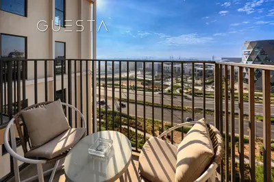 a balcony with chairs and a table and a view of a street at Collective Tower, Dubai Hills Estate in Dubai