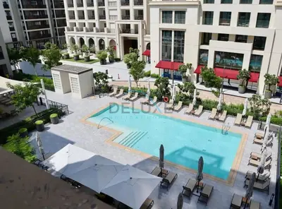 an overhead view of a pool with chairs and a building at Bright 2BR in Surf at Creek Beach Building 1, Creek Harbour by Deluxe Holiday Homes in Dubai