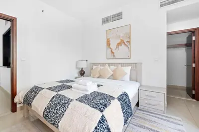 a bedroom with a bed with a black and white blanket at Vacay lettings 1 bed close to down town Fountain View in Dubai