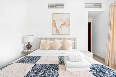 a bedroom with a bed with a blue and white quilt at Vacay lettings 1 bed close to down town Fountain View in Dubai