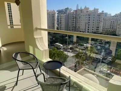 a balcony with two chairs and a view of a city at 2 Bedroom beach front apartment in Dubai