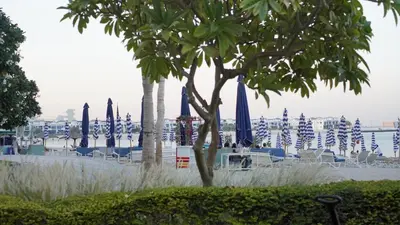 a beach with chairs and umbrellas and chairs and tables at 2 Bedroom beach front apartment in Dubai