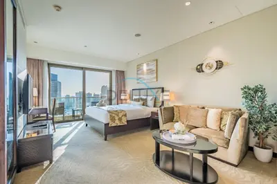 a hotel room with a bed and a couch at Lovely Studio in The Address Residence Dubai Marina by Deluxe Holiday Homes in Dubai
