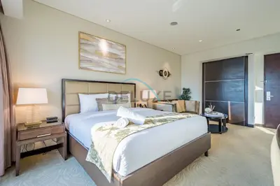 a bedroom with a large bed and a table with a lamp at Lovely Studio in The Address Residence Dubai Marina by Deluxe Holiday Homes in Dubai
