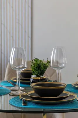 a table with two wine glasses and a plate of food at Casa Azure in Dubai