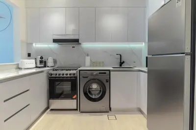 a kitchen with a washing machine and a stove at Casa Azure in Dubai