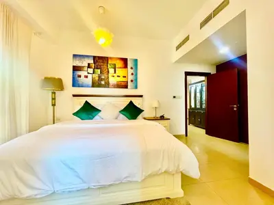 a bedroom with a white bed and a red door at One bedroom apartment available in Front of Marina Beach Dubai in Dubai