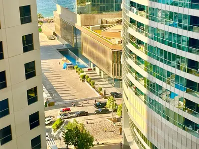 an aerial view of a city with a tall building at One bedroom apartment available in Front of Marina Beach Dubai in Dubai