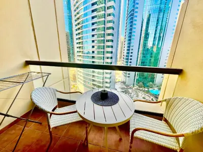 a balcony with a table and chairs and a large window at One bedroom apartment available in Front of Marina Beach Dubai in Dubai