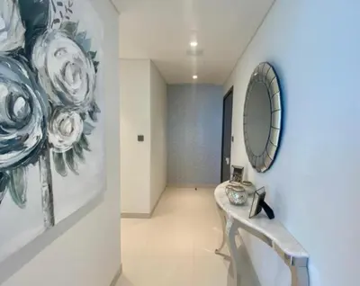 a hallway with a table and a mirror on a wall at Dubai Harbour in Dubai